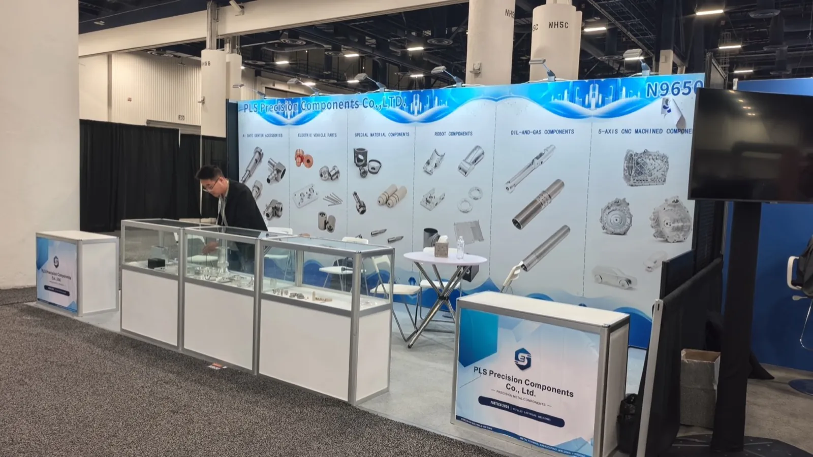 Stand de PLS Precision Components à FABTECH 2026, Las Vegas Convention Center, avec le mur des familles de produits et les vitrines d&rsquo;échantillons