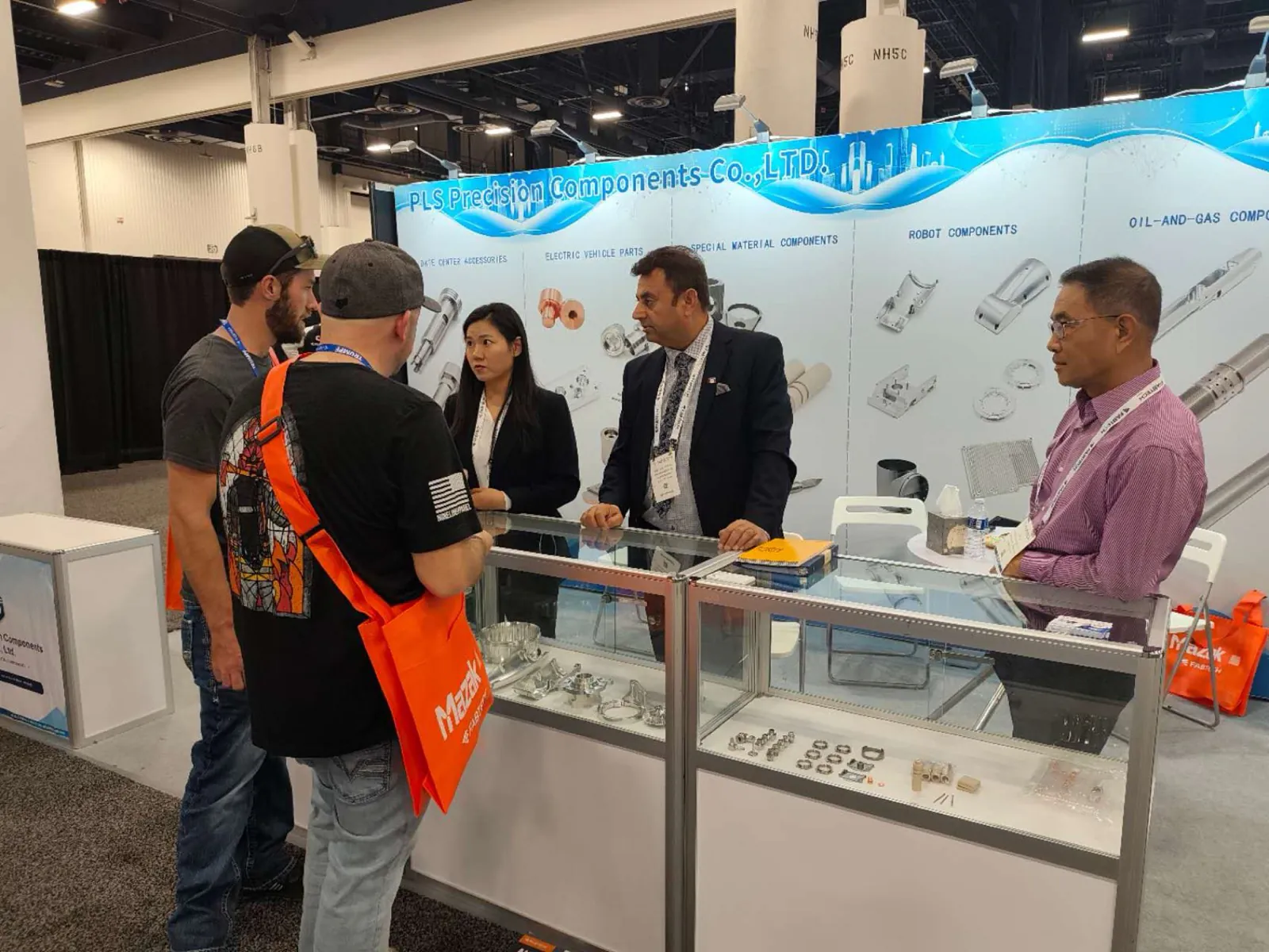 Groupe de visiteurs réunis autour du comptoir du stand PLS Precision à FABTECH 2026, Las Vegas
